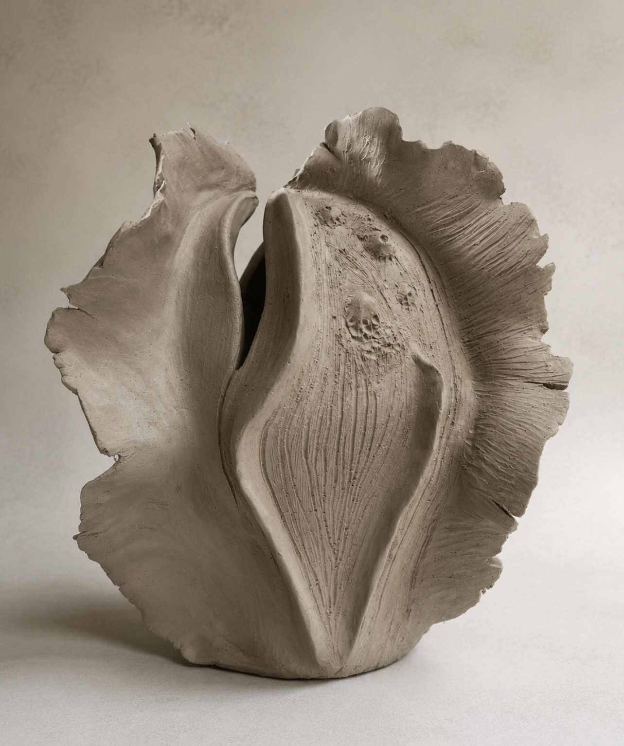 Organic handbuilt ceramic vessel with sweeping textured edges