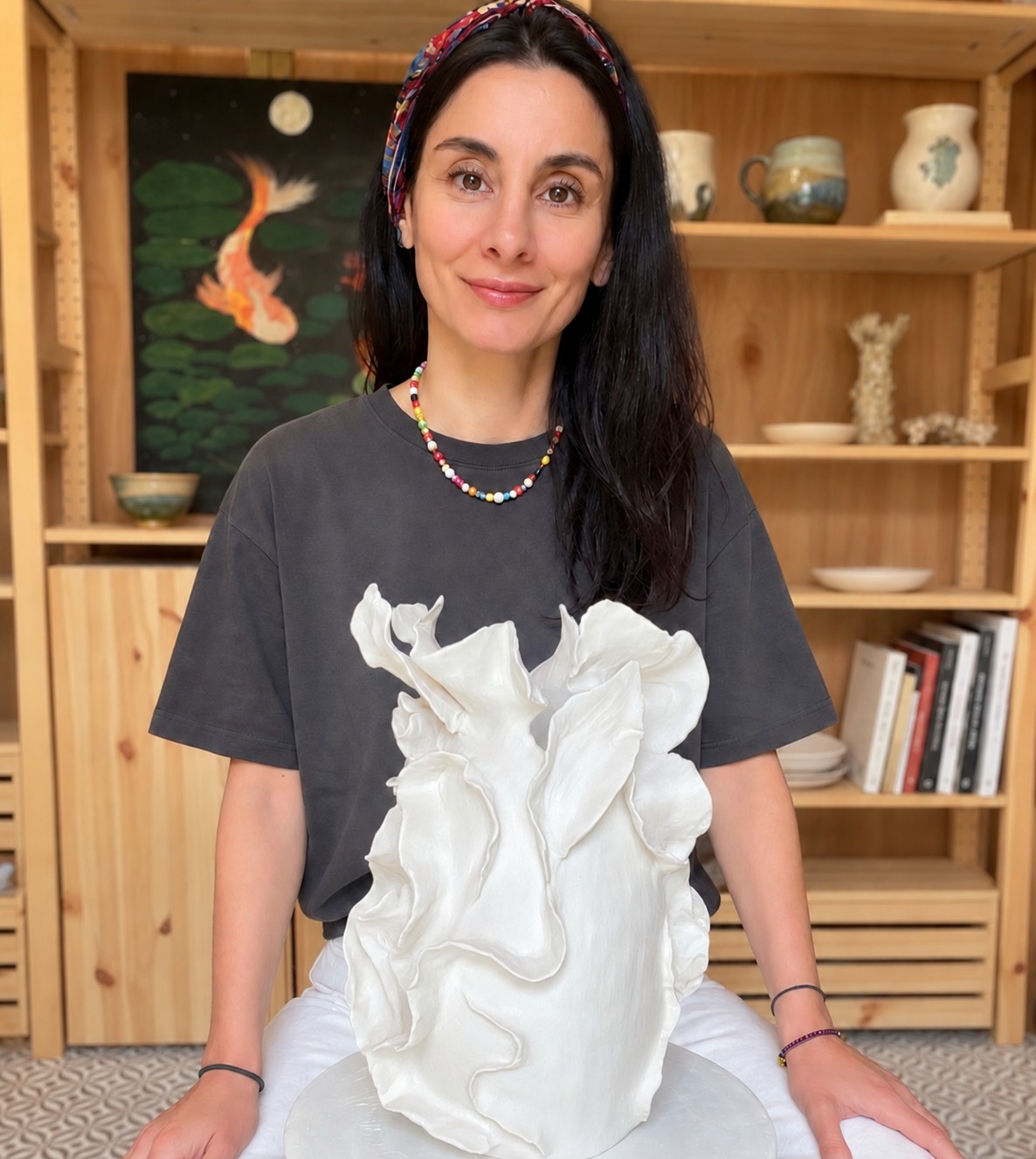 Hazal, founder of Mana Studio, with her handbuilt white sculptural vase in her Corbridge studio