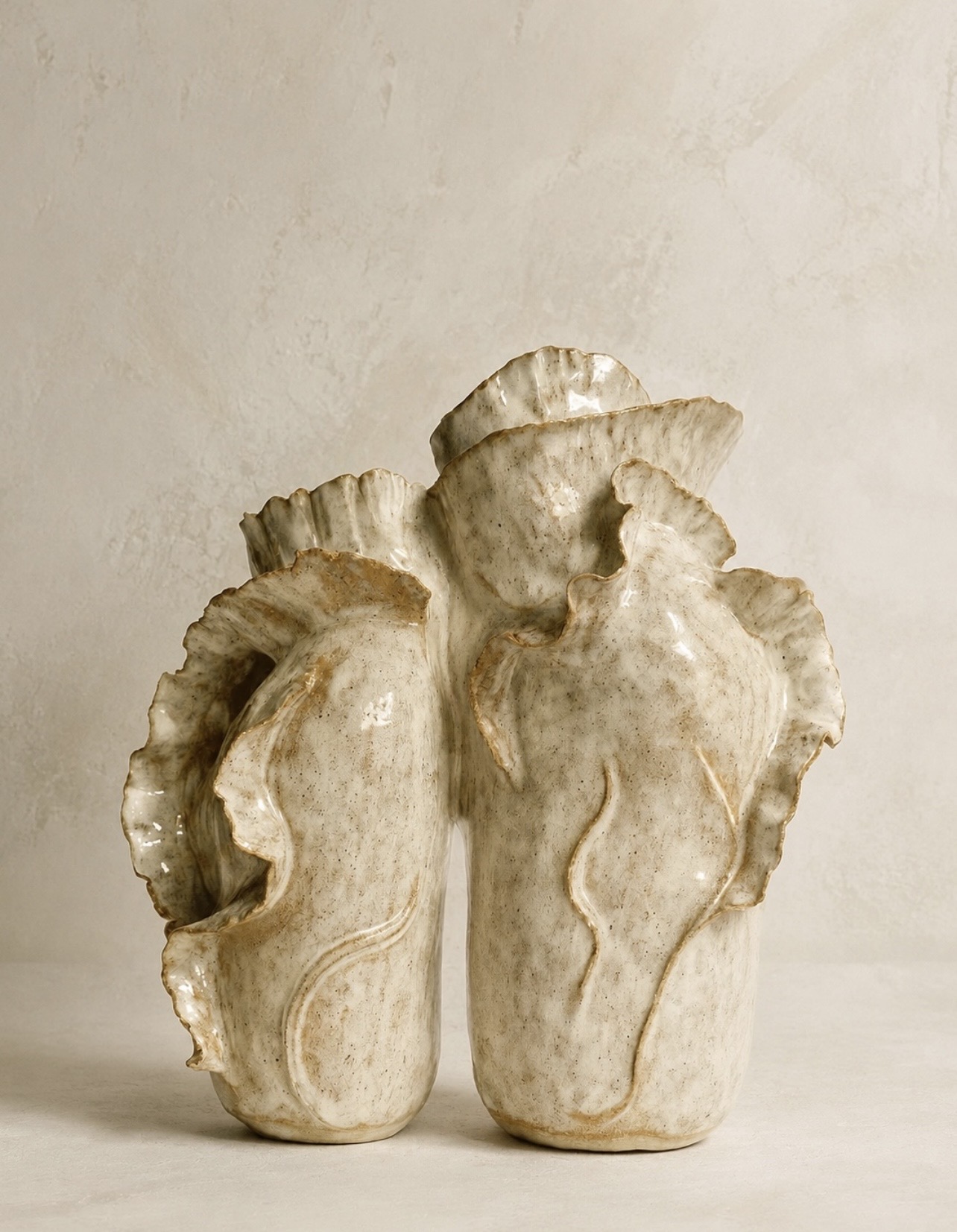Pair of tall ivory sculptural vessels with flowing petal-like forms