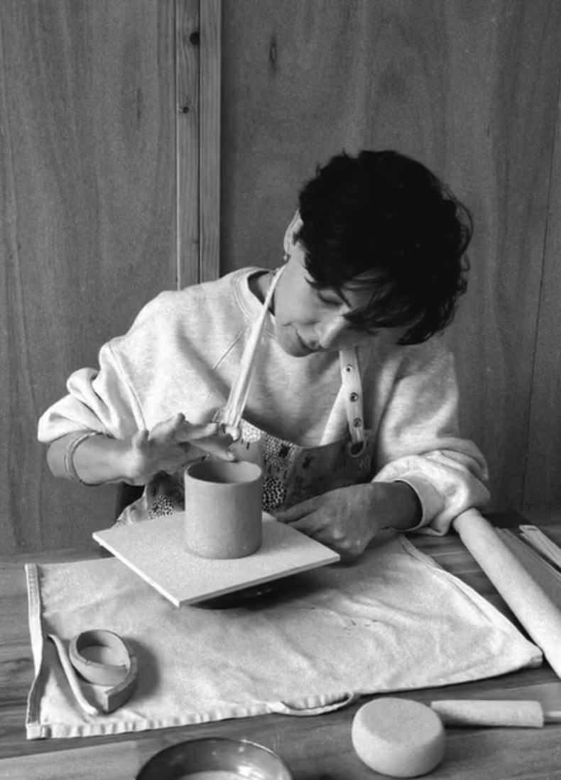 Guest carefully shaping a clay cup during a pottery workshop